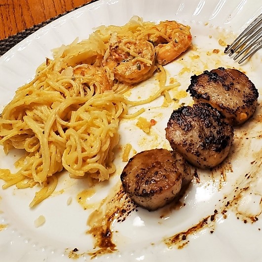 Shrimp pasta and scallops on plate